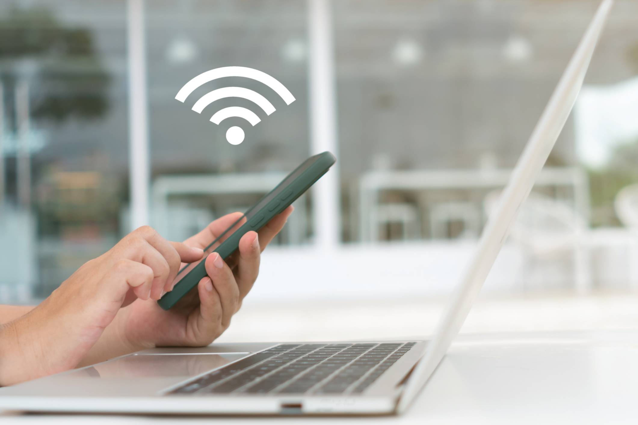 In a cafe shop background, a woman uses a laptop with a wifi icon. Social networking concept.
